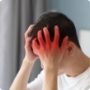 A man grabbing his head with both hands showing signs of headache