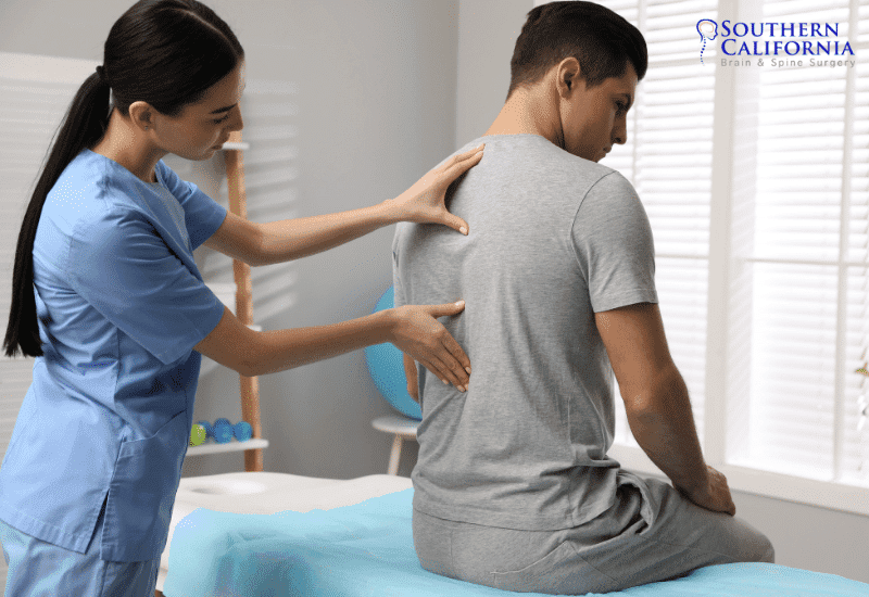 A doctor helping patient with back pain, Neurosurgeon Los Angeles, Spine Surgeon in Los Angeles