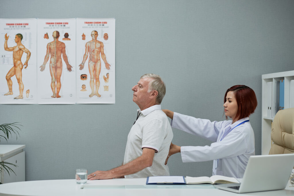 Chiropractor assessing a patient's spine, discussing how the recovery time for anterior cervical discectomy and fusion can vary based on individual health and the extent of the surgery.