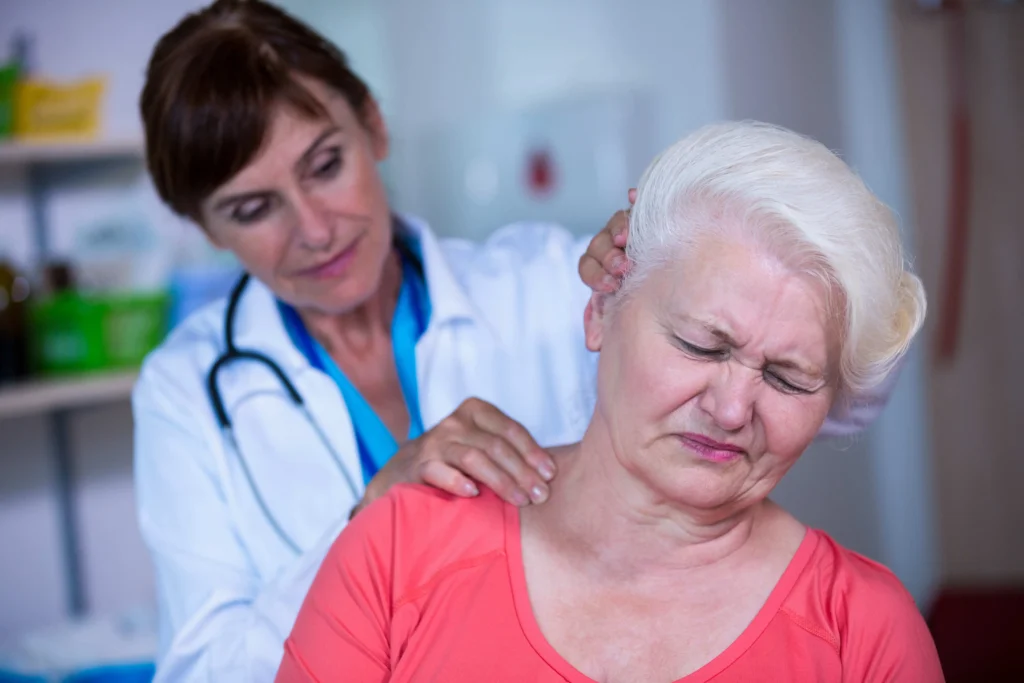 Doctor examining elderly patient's neck pain to determine if cervical spine surgery neck is necessary.